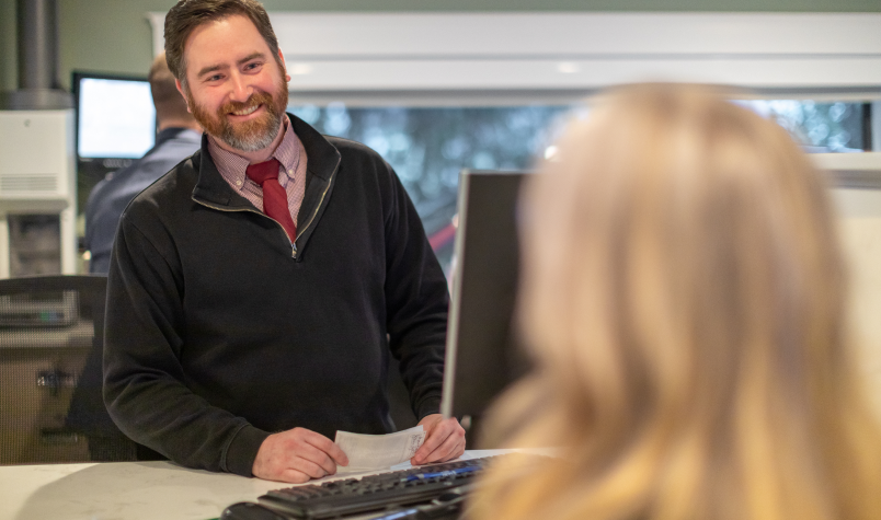 Banker smiling at woman in branch office