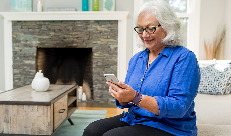 Older woman with cell phone at home