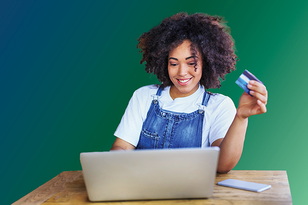 Black business woman with credit card and laptop