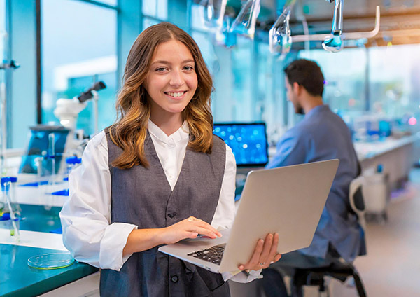 Woman standing with laptop in med startup lab