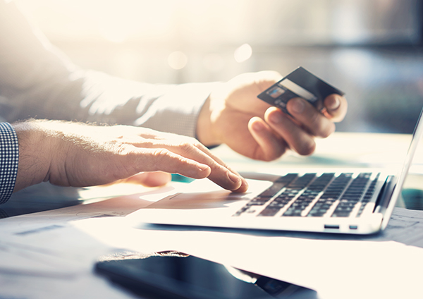 Person using laptop and debit card